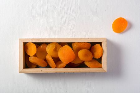 Delicious and healthy dried apricots. Freshly dried. On a white background in wooden box.の写真素材