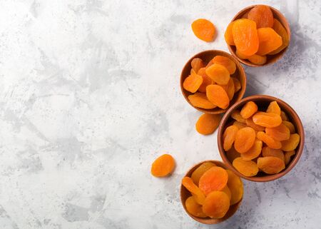 Delicious and healthy dried apricots. Freshly dried. On a white background in wooden bowlsの写真素材