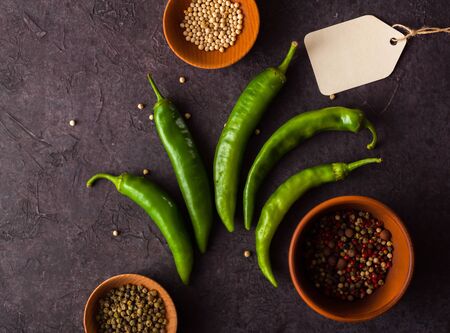 A few green hot peppers shot from above on a dark stone background. Plenty of space for textの写真素材