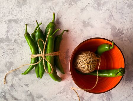 A few green hot peppers shot from above on a light stone background. Plenty of space for textの写真素材