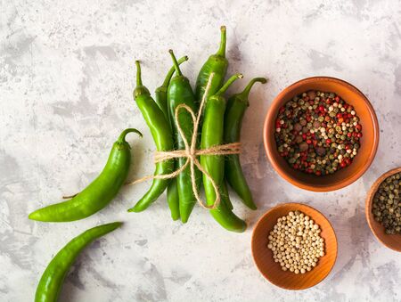 A few green hot peppers shot from above on a light stone background. Plenty of space for textの写真素材