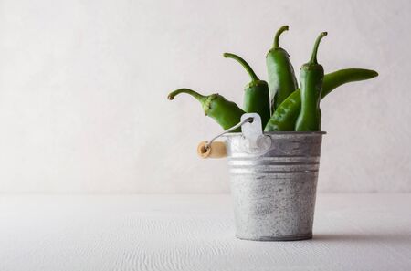 A variety of green hot peppers in a small bucket. Seasoning for a delicious dish.の写真素材
