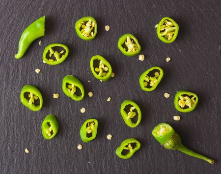 Chopped green pepper spread out on a dark stone background. View from above. For a menu or to advertise a restaurant or cafe.の写真素材