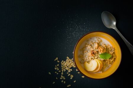 morning oatmeal for breakfast. Early morning and healthy diet food. Proper nutrition. Dark stone background. Plenty of room for text.の写真素材