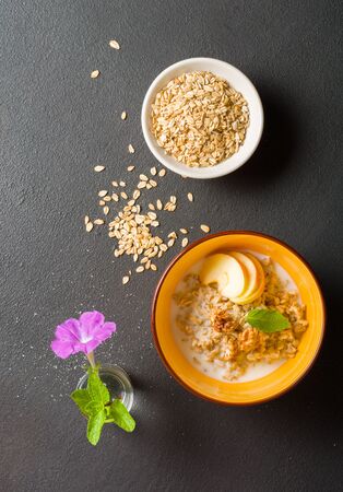 morning oatmeal for breakfast. Early morning and healthy diet food. Proper nutrition. Dark stone background. Plenty of room for text.の写真素材