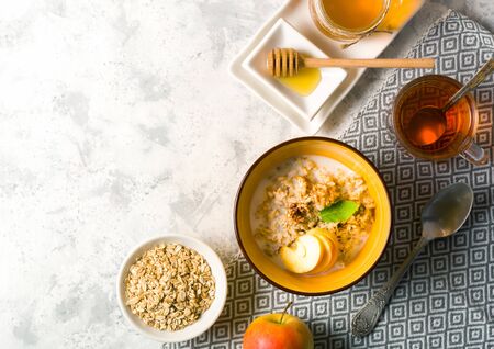 Morning oatmeal for breakfast. Early morning and healthy diet food. Proper nutrition. White stone background. Plenty of space for textの写真素材