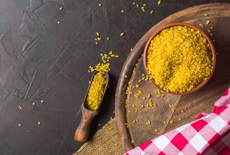 Bulgur on a dark background. wholesome organic food for breakfast or diet. Natural fabrics and earthenware. Copy space.の写真素材