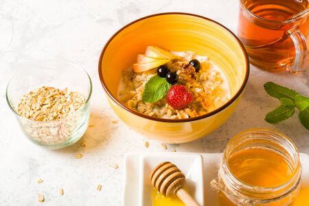 Morning oatmeal for breakfast. Early morning and healthy diet food. Proper nutrition. White stone background. Plenty of space for text.の写真素材