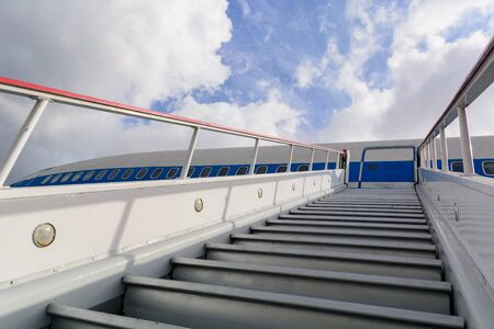 Ladder for departing passengers near the plane. Against the background of blue sky and clouds. Stairway to Heavenの写真素材