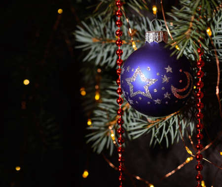A blue glass ball on a Christmas tree. Dark background.の写真素材