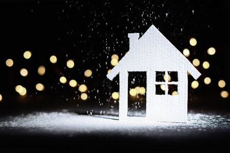 Small cardboard house on a dark winter background.の写真素材