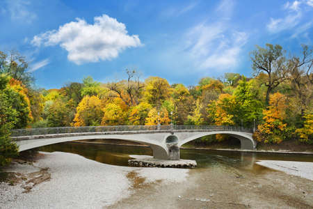 Lonely stone bridge over autumnal scene in Munichの写真素材