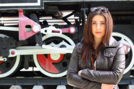 Beautiful caucasian girl in front of vintage locomotiveの写真素材