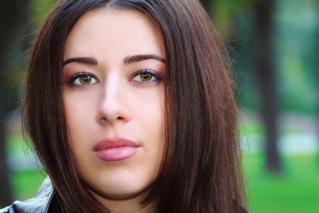 Portrait of a young pretty brunette girl in the parkの写真素材
