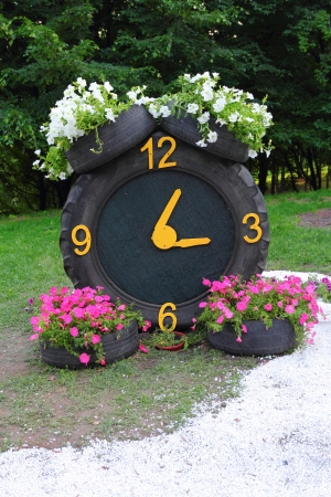 Rubber tyres with petunia flowers on them forming a clockの写真素材