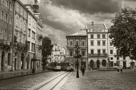 LVIV, UKRAINE - MAY 8, 2016:  The center of Lviv - The Market Square. Two trams passing along the street. Black and white photo. Ukraineのeditorial素材