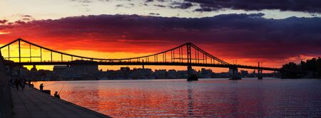 KIEV, UKRAINE - JULY 22, 2016: Breathtaking sunset over Trukhaniv bridge in Kiev. People enjoying the scene, the Dnieper river bank is occupied by fishermen.のeditorial素材