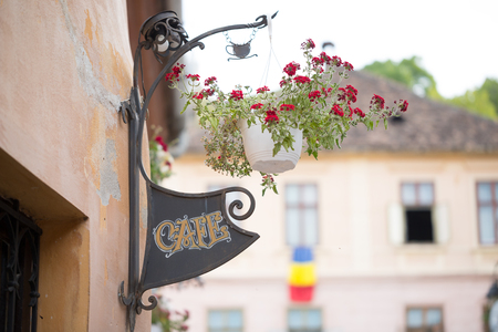 The sign 'Cafe' and the flowers at local restaurant in Sighisoara, Romaniaの写真素材