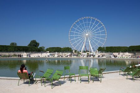Paris, France - 19 May, 2018: A lady sitting on the chair and ejnoying the view on the Ferris Wheel at the Place de la Concorde.のeditorial素材