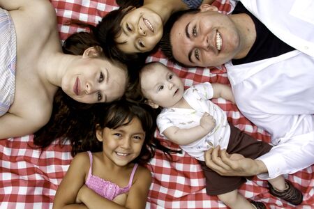 Family Laying on Picnic Blanket Posing for Pictureの写真素材