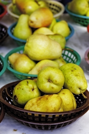 Baskets of fresh pears on table for sale at local farmer s marketの写真素材