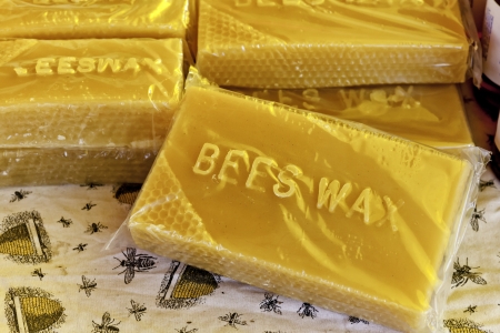 Bars of bees wax for sale on colorful tablecloth at local marketの写真素材