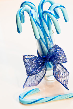 Glass of blue candy canes with blue glitter ribbonの写真素材
