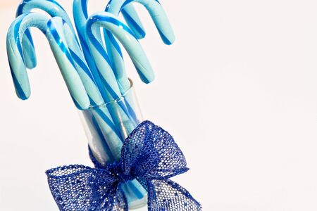 Blue candy canes in glass with blue ribbonの写真素材
