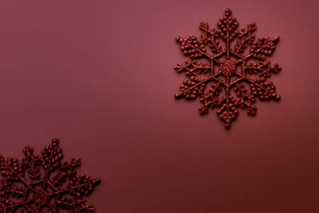 Spotlighted red glitter snowflake on red holiday backgroundの写真素材