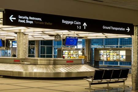 Baggage claim with airport directional signs aboveのeditorial素材