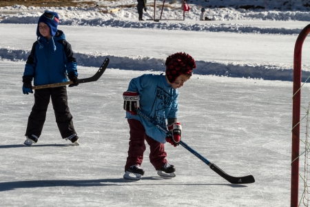 Little boy learning to play hockey on outdoor skating rinkのeditorial素材