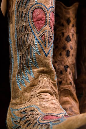 Womens cowgirl boots decorated with a peace sign in the shape of a heartの写真素材