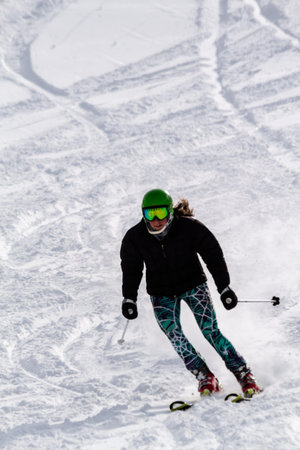 Female skier skiing down hill in fresh snow at Ski Days during 50 Year Steamboat Springs winter celebrationのeditorial素材