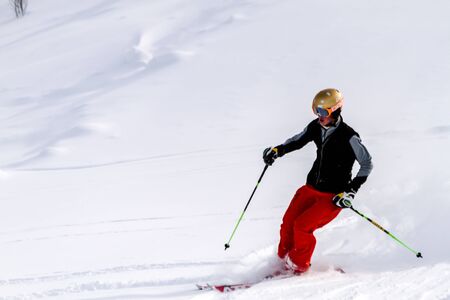 Male skier in red ski pants skiing in fresh snow at Ski Days during 50 Year Steamboat Springs winter celebrationのeditorial素材