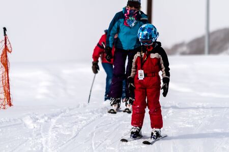Young boy skiing with family at ski resort at Ski Days during 50 Year Steamboat Springs winter celebrationのeditorial素材
