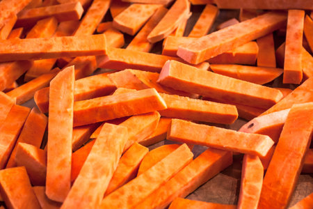 Fresh cut slices of sweet potatoes made into fries, ready for cooking