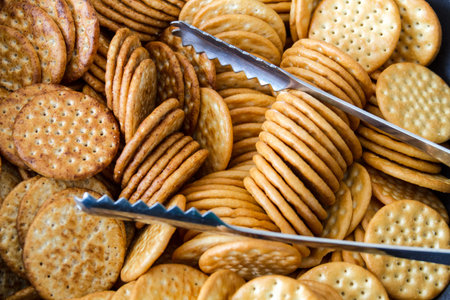 Serving platter filled with round salty crackers and silver tongs