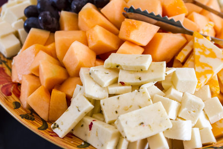 Close up of hors d'oeuvre platter of assorted cheeses and fruitsの写真素材