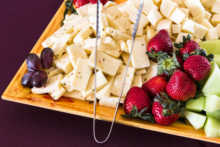 Assorted fruits and cheese hors d'oeuvres on decorated serving platterの写真素材