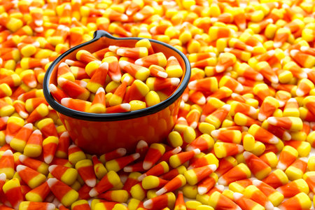 Orange pumpkin bowl filled with candy corn candy