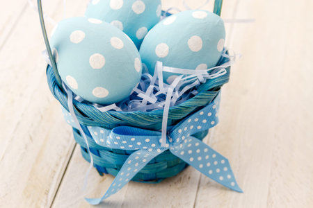 Blue Easter basket filled with blue polka dot Easter eggs and blue grassの写真素材