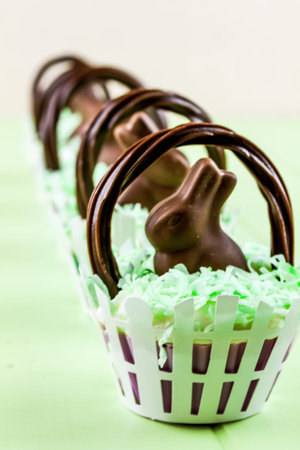 Easter basket cupcakes with chocolate bunny and coconut grass