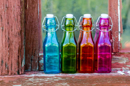 Colored vintage bottles sitting on old wooden windowの写真素材