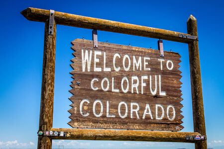 Welcome to Colorful Colorado wooden roadside sign with bright blue sunny sky in backgroundの写真素材