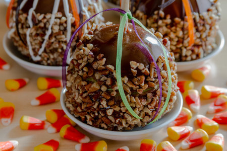 Close up of gourmet caramel apples with nuts and chocolate drizzle sitting in small white plates...