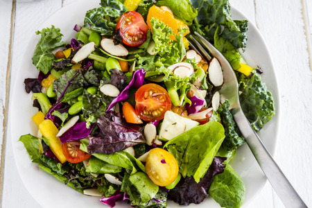 Fresh organic super food salad in white bowl with fork on sideの写真素材