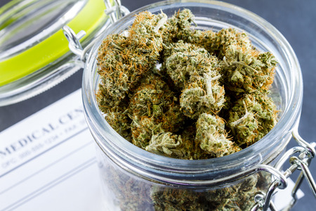 Close up of medical marijuana buds in glass container on black backgroundの写真素材
