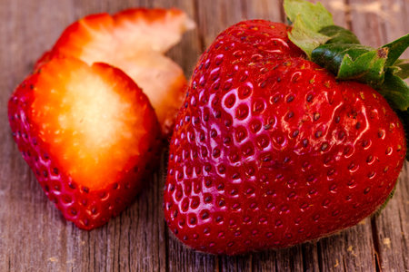 Close up of single strawberry with slices in backgroundの写真素材