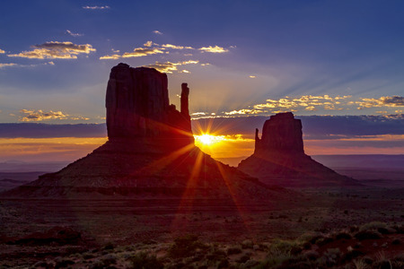 Amazing sunrise clouds over iconic Monument Valley, Arizona Utah, USA with sunflare around west mitten butteの写真素材