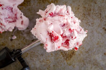 Close up of fresh strawberry ice cream in ice cream scoop sitting textured backgroundの写真素材